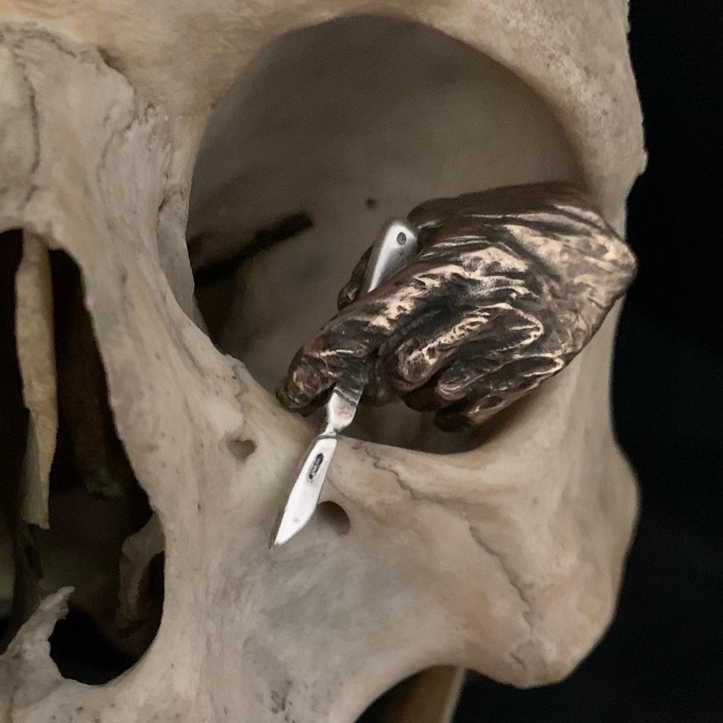 Broche main gantée et scalpel